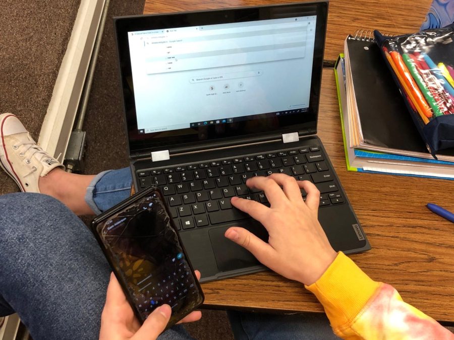 A student at SEHS using multiple forms of technology simultaneously.