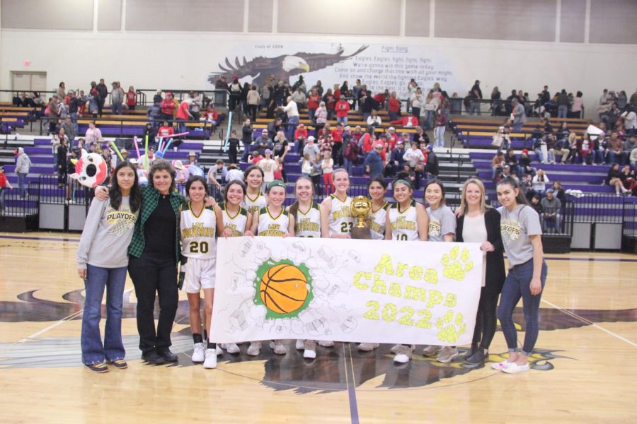 The Lady Wolverines and their Area Champion sign made by Diana and Micky Fuentes