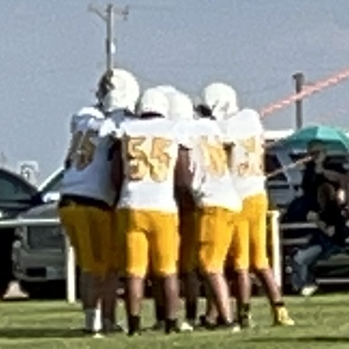 The JV team in a huddle preparing for their next play in the game.