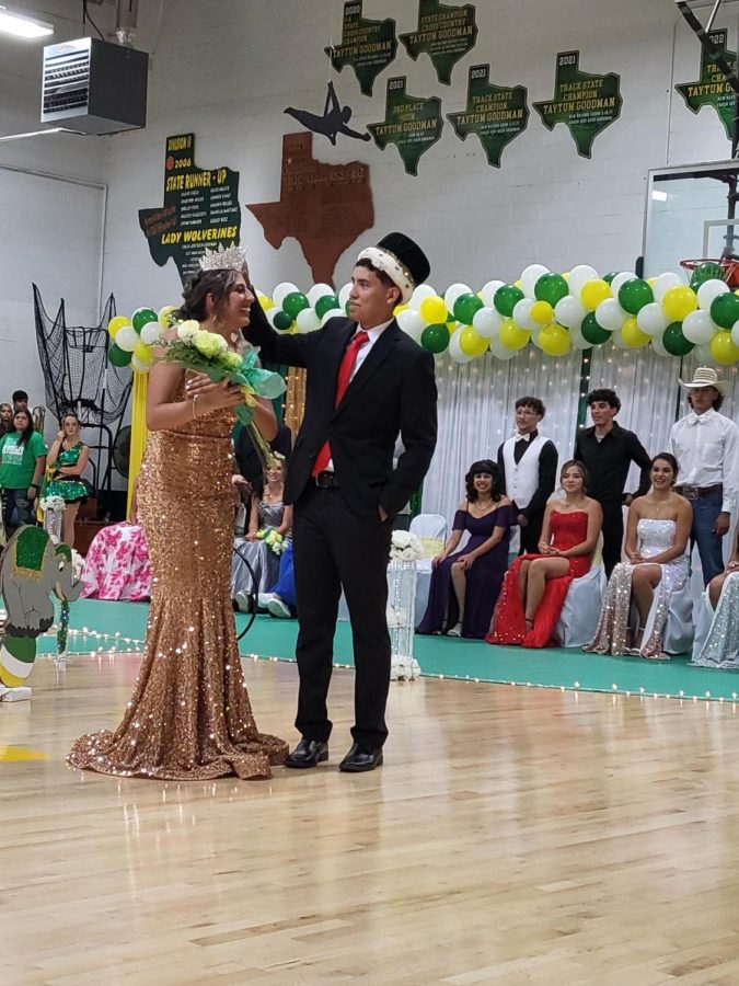 Homecoming King Alex Alvarez trying to place crown on Homecoming Queen Halee Toscanos head.