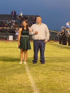 Eight grade homecoming candidate Ennah Mosqueda standing with father Jason Mosqueda during halftime.