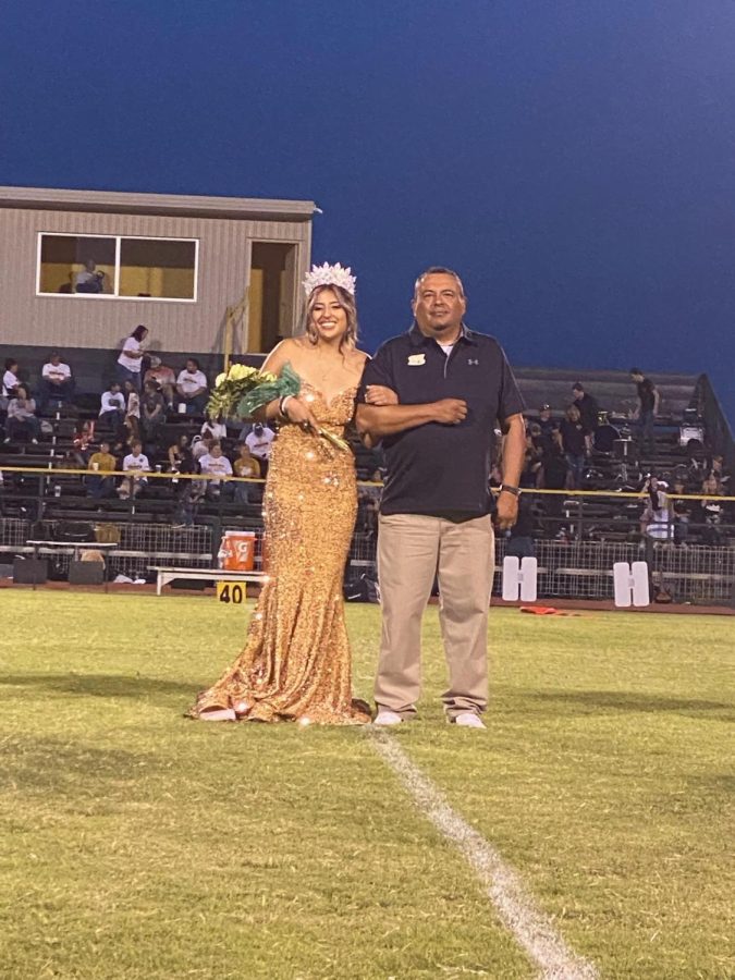 Senior and homecoming queen Halee Toscano standing with father Gabriel Toscano during halftime.