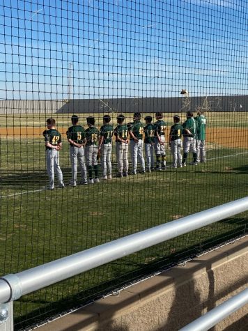 The Wolverine baseball team lined up for the playing of the Star Spangled Banner.  